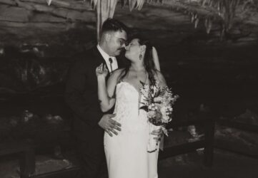 Wedding portrait of couple in cave. With stalagtite behind them. Photo in black and white.